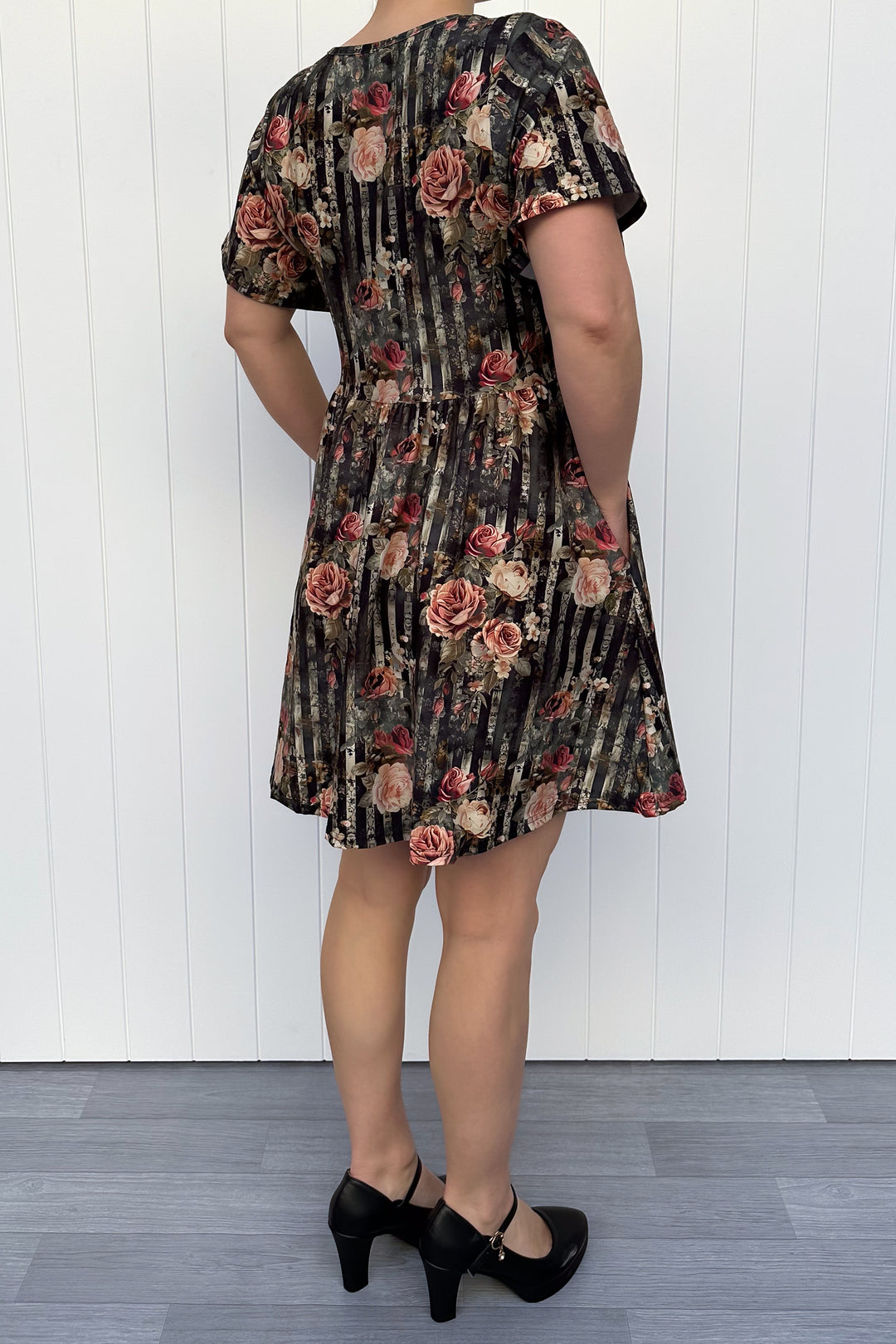 Person wearing a floral dress with a white background